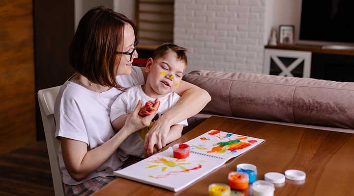Mum painting with her son who has Cerebral Palsy